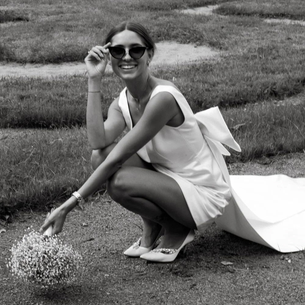 bride crouched down wearing a Short Boho V-Neck Wedding Dress with Large Bow and Detachable Train