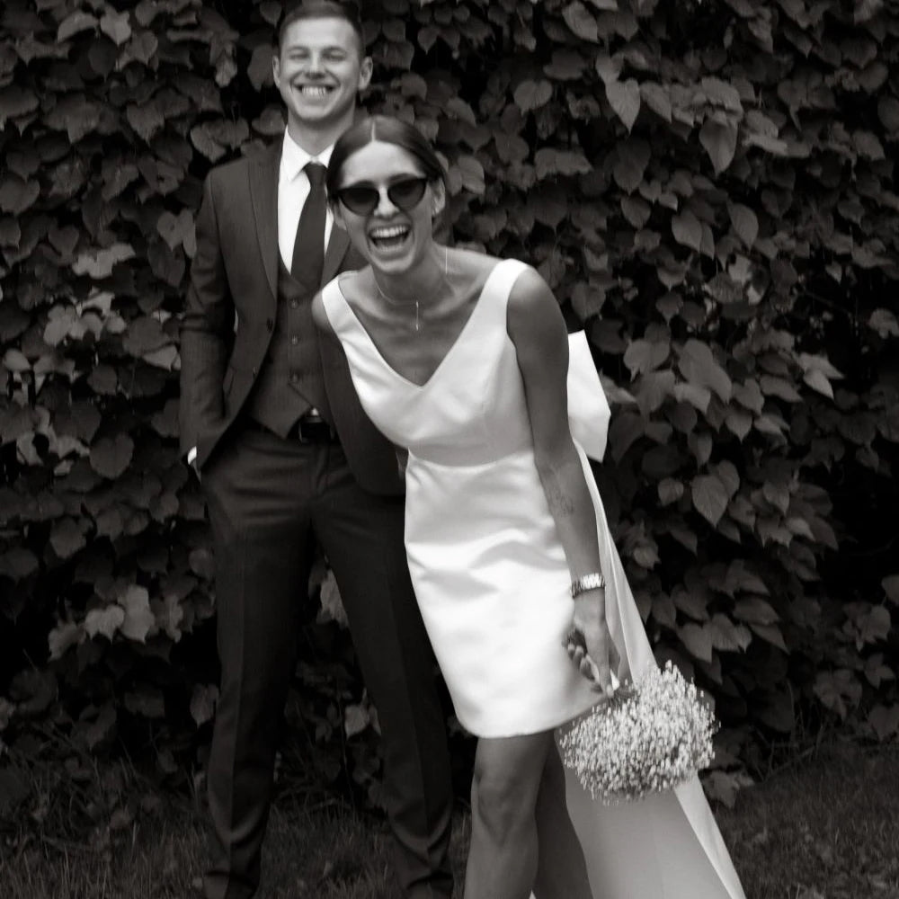 bride laughing wearing a Short Boho V-Neck Wedding Dress with Large Bow and Detachable Train