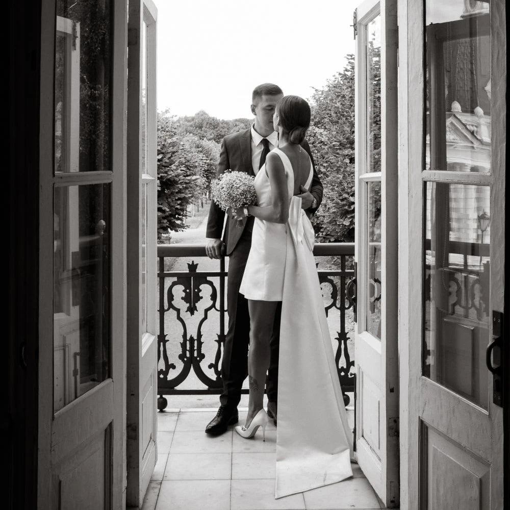 happy couple on the balcony wearing a Short Boho V-Neck Wedding Dress with Large Bow and Detachable Train