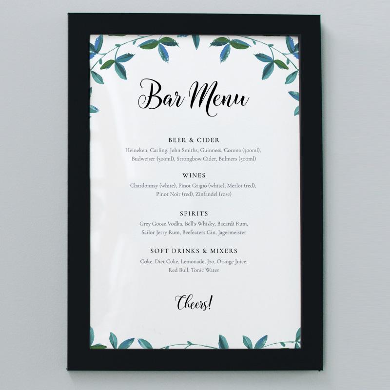 A2 outdoor wedding bar menu with green foliage in a black frame