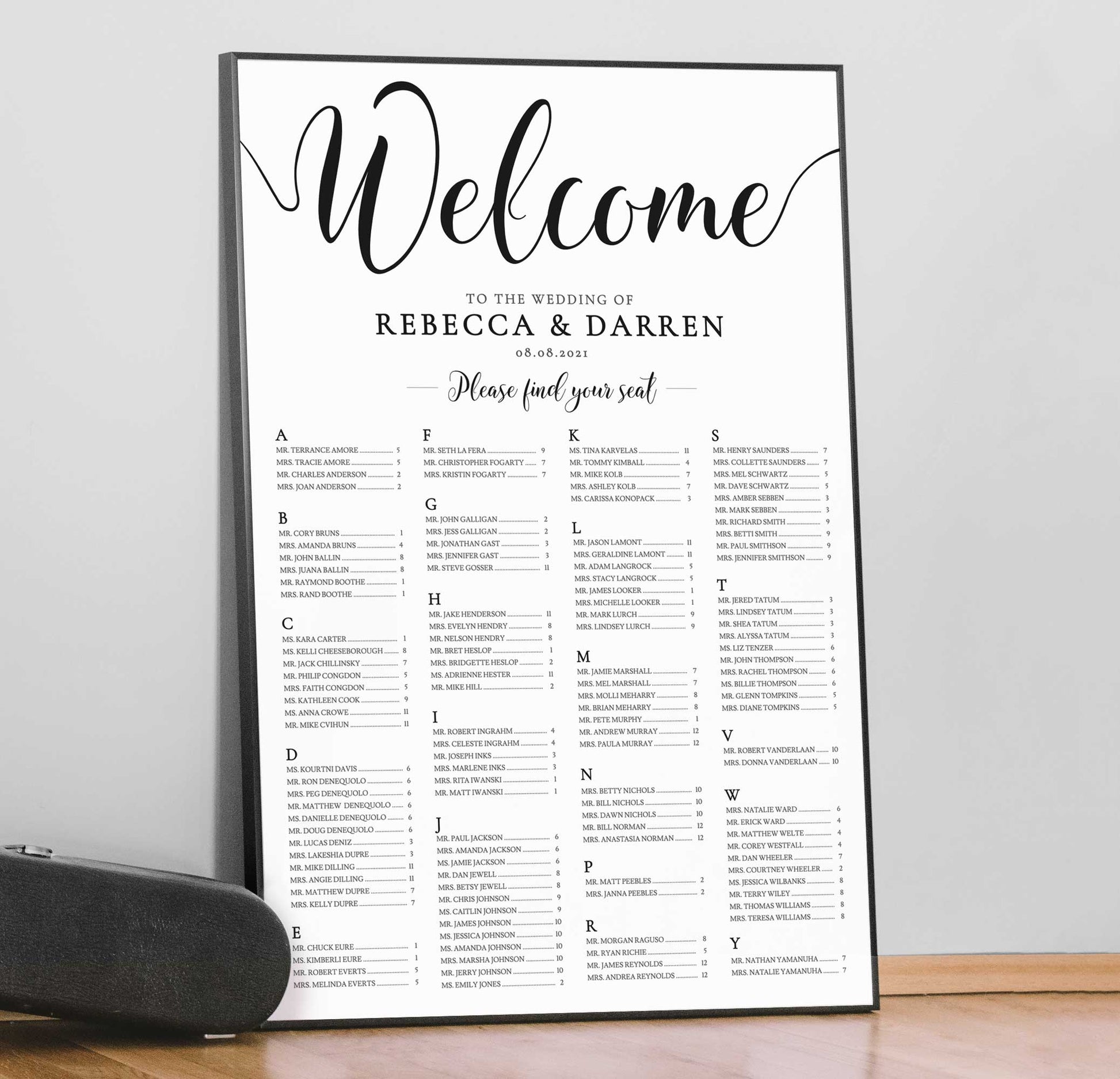 black and white alphabetical_ seating chart in a large black frame leaning against a wall