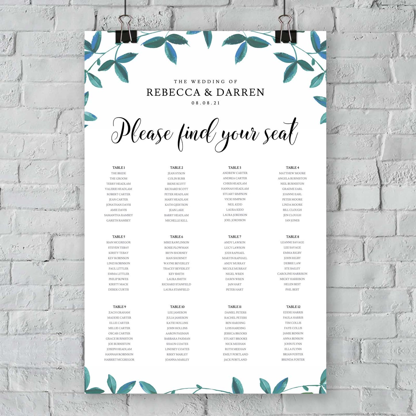 seating chart with 12 tables and green foliage border hanging from an exterior wall