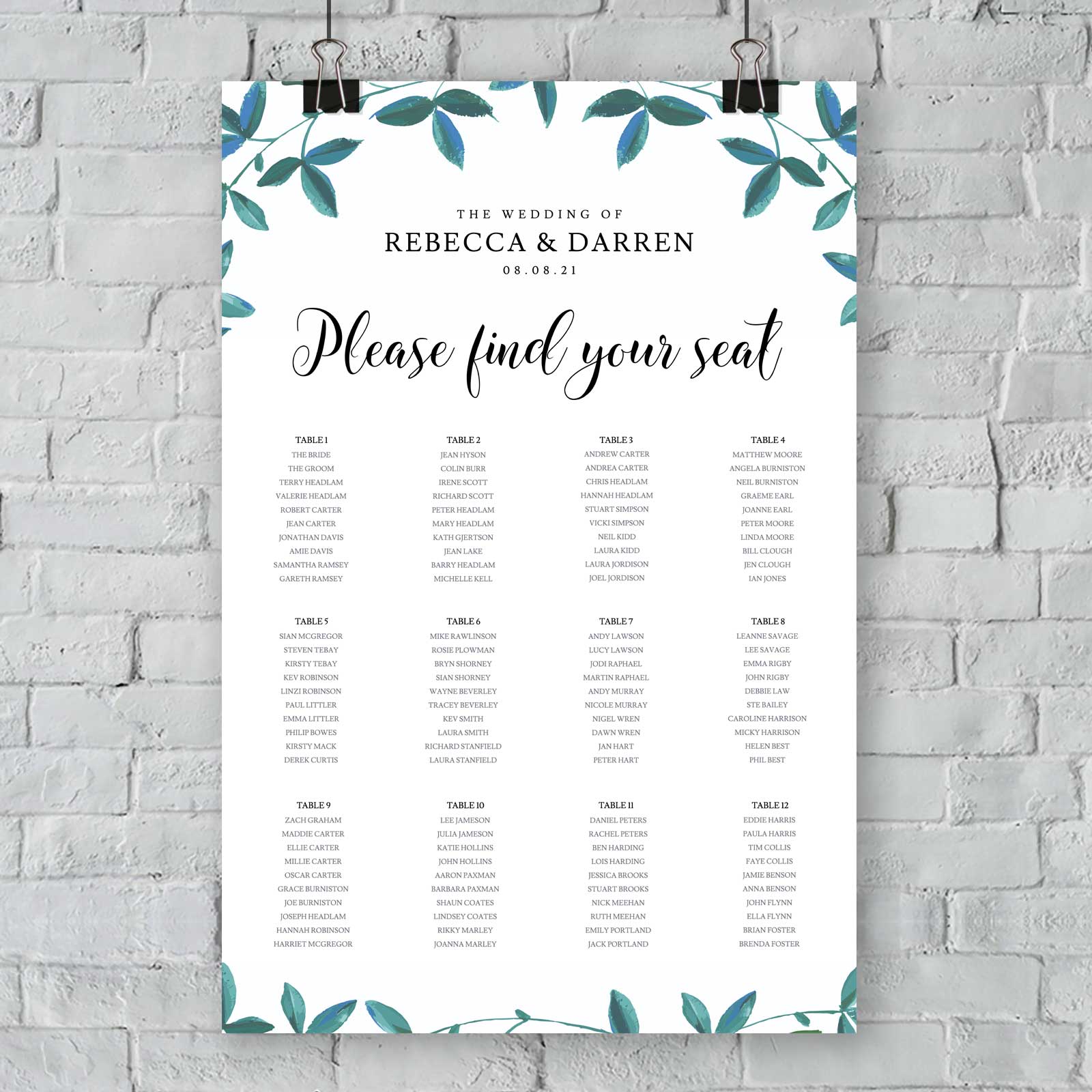 seating chart with 12 tables and green foliage border hanging from an exterior wall