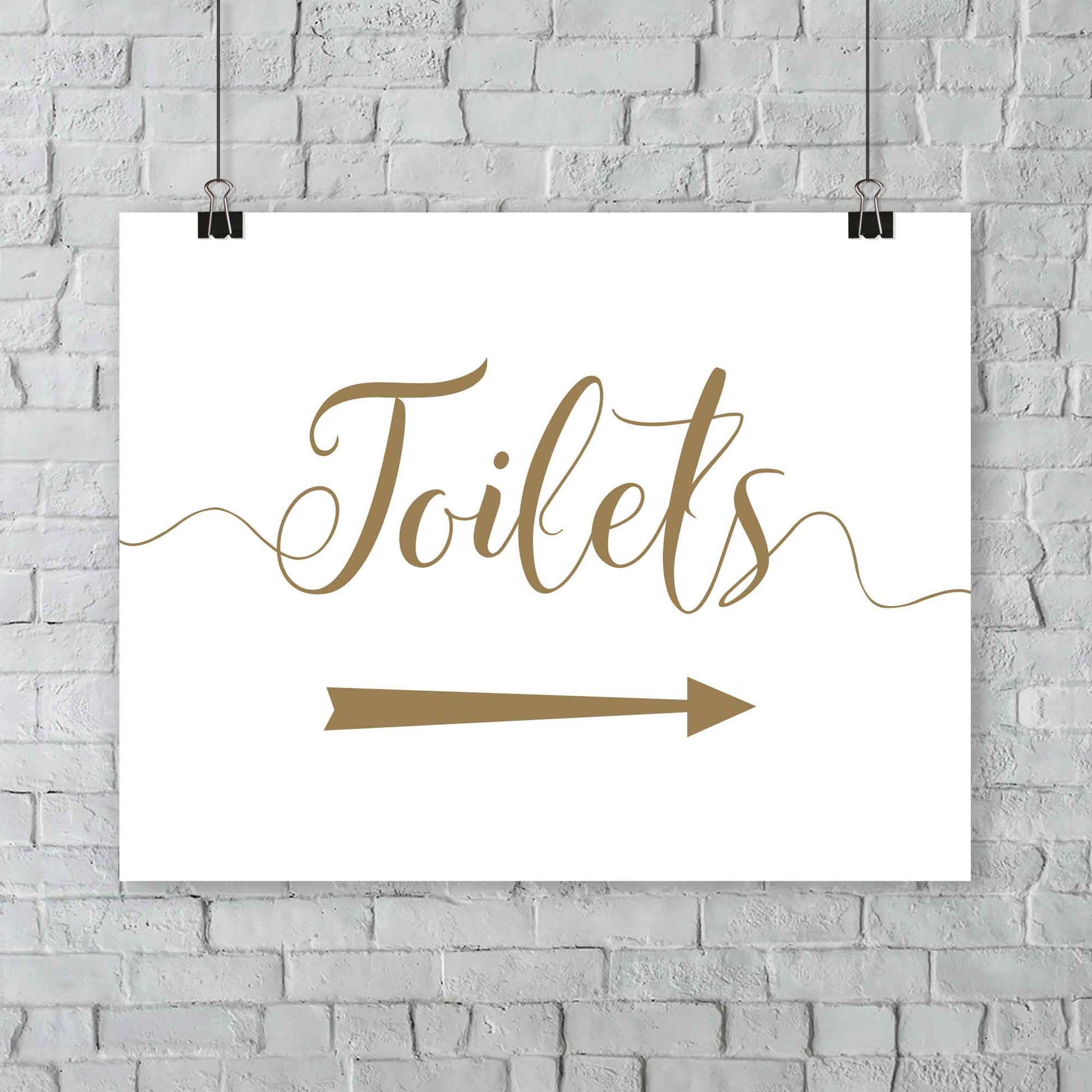 gold toilets arrow sign at outdoor wedding