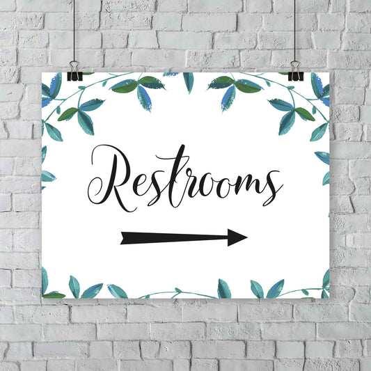 boho wedding restrooms right arrow sign with green foliage border hanging from an outdoor wall