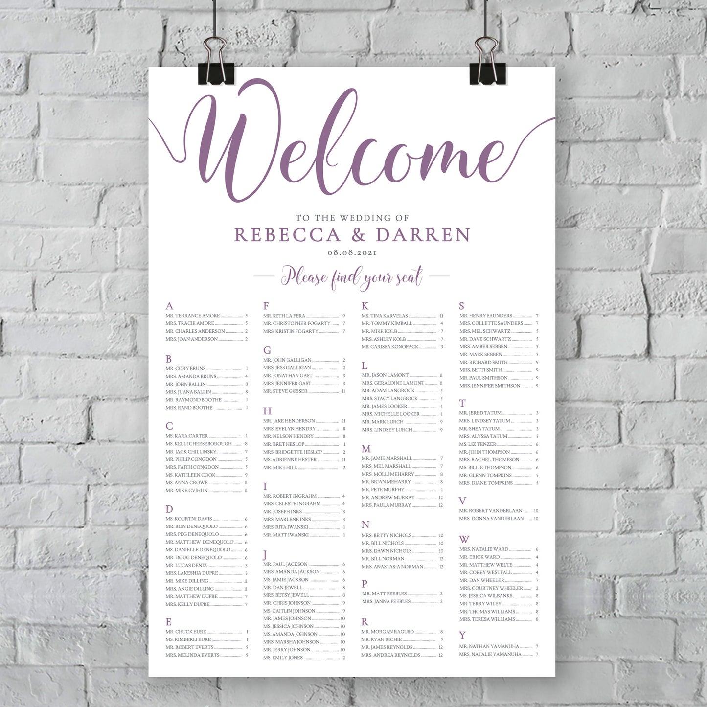 large print of purple wedding seating chart on wall