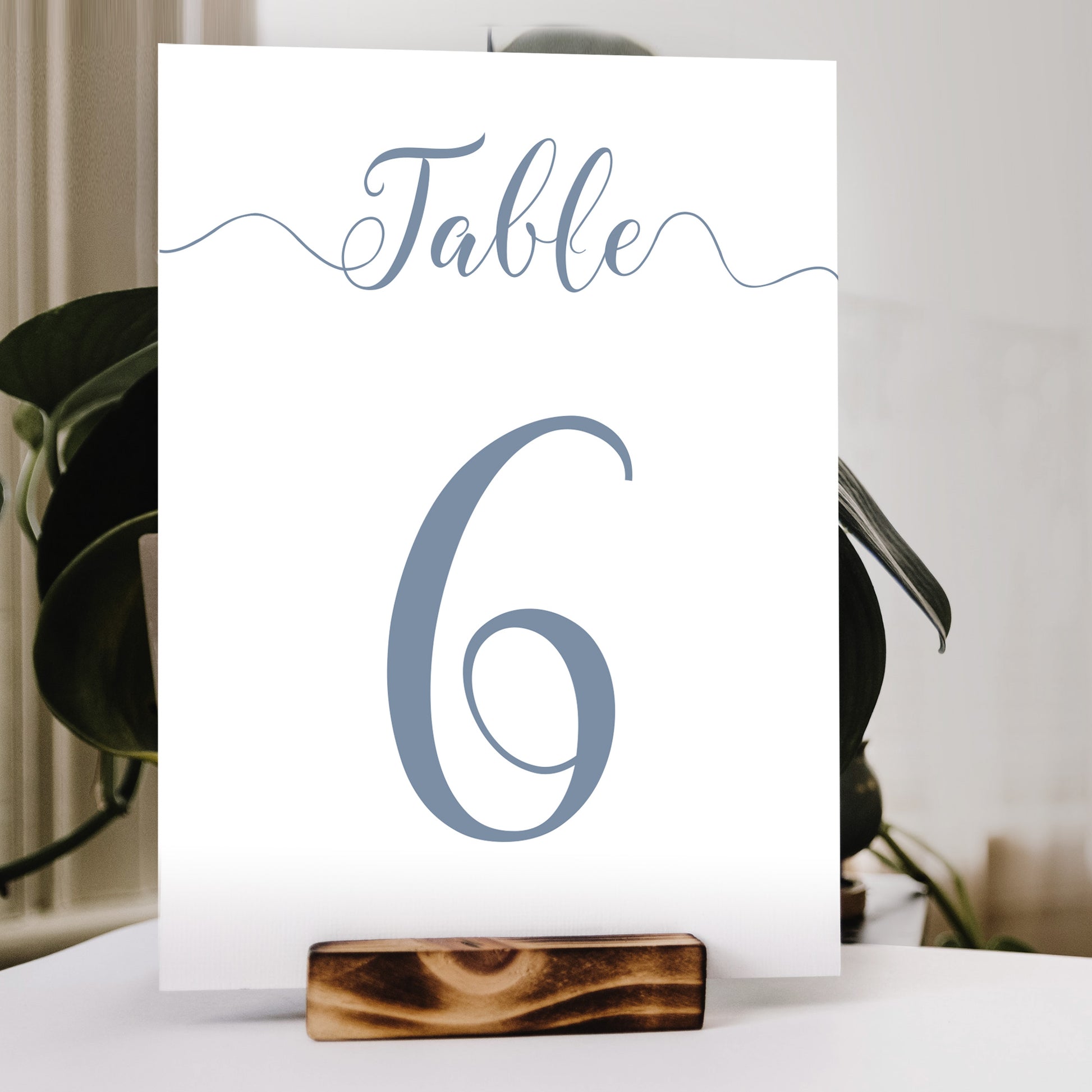 misty blue table number print in a wooden stand at a wedding