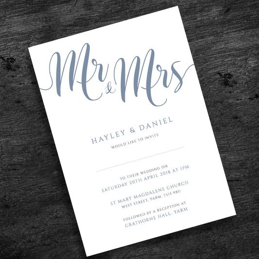pale blue wedding invitation on wooden table