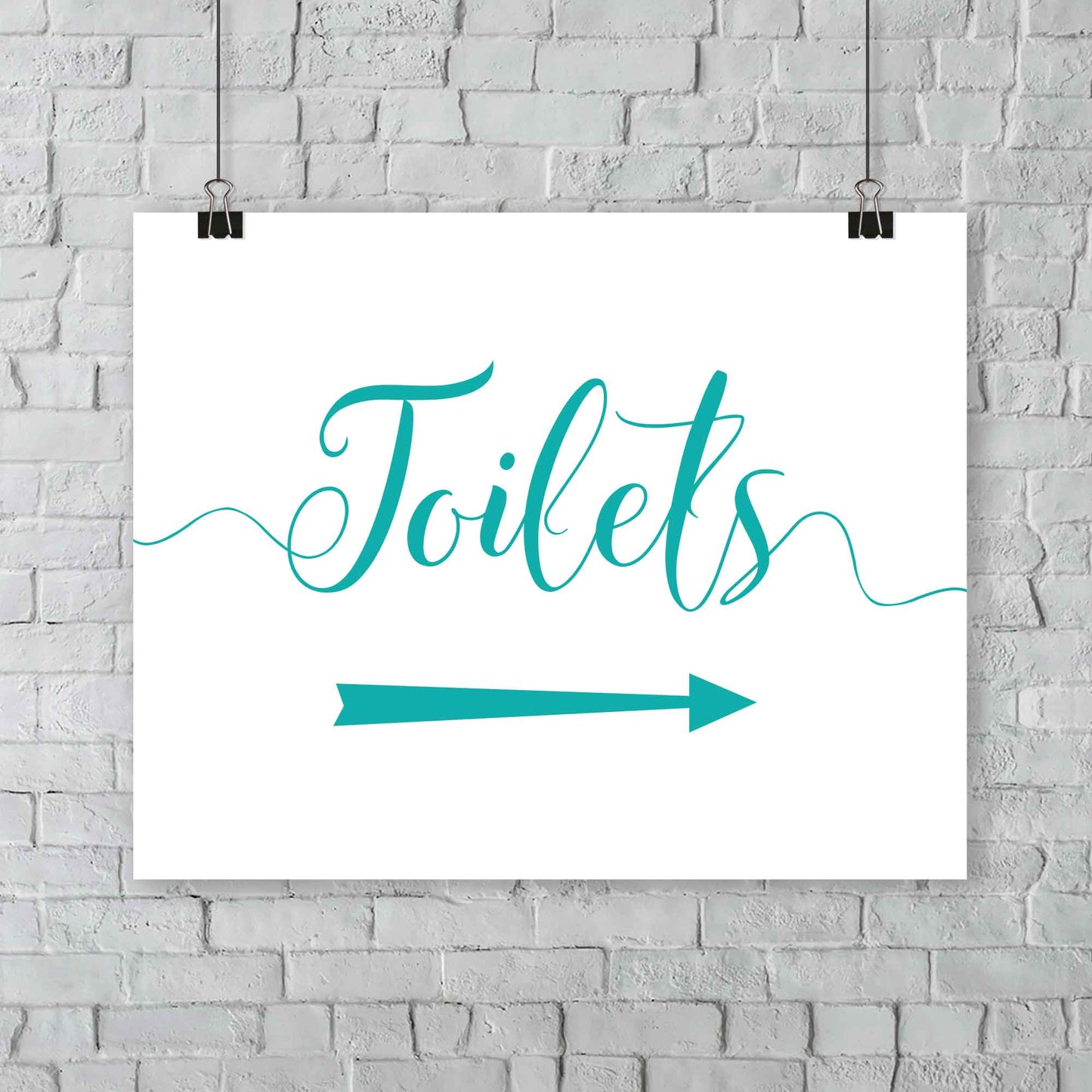 printed turquoise wedding toilets arrow signage on a wall
