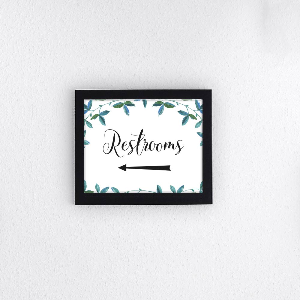 restrooms left arrow sign with eucalyptus border framed on a textured wall