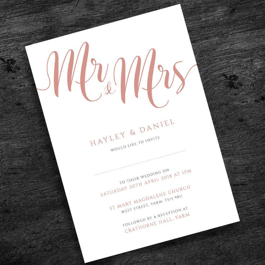 rose gold wedding invitation on wooden table