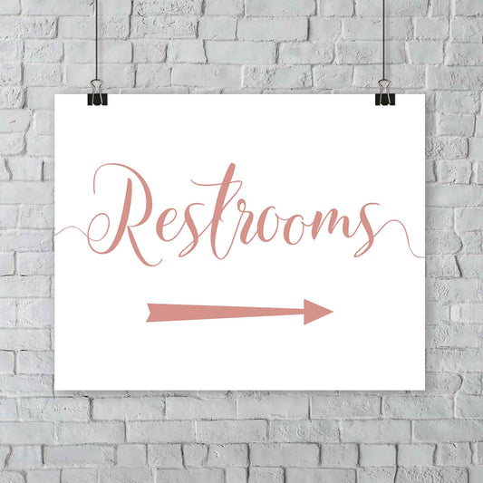 rose gold wedding restrooms arrow signage hanging from a wall