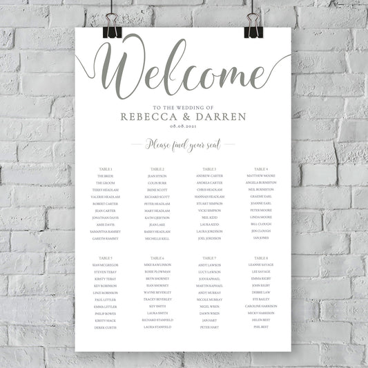 sage green seating chart hanging on a white wall