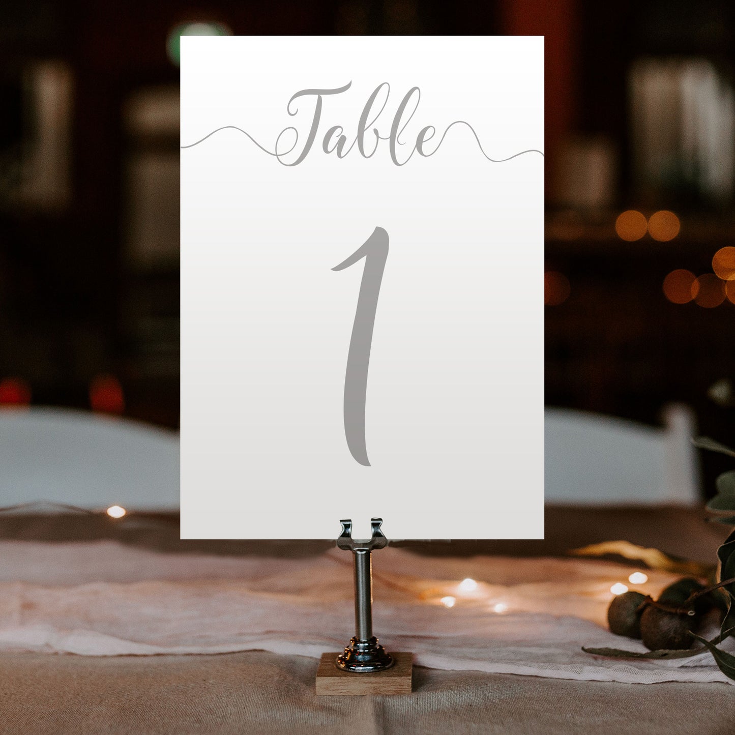 silver table number on a wedding table at an evening reception