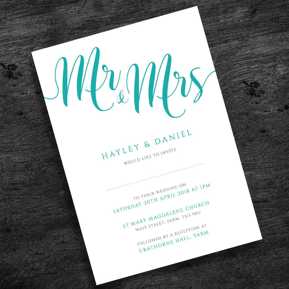 turquoise wedding invitation on wooden table