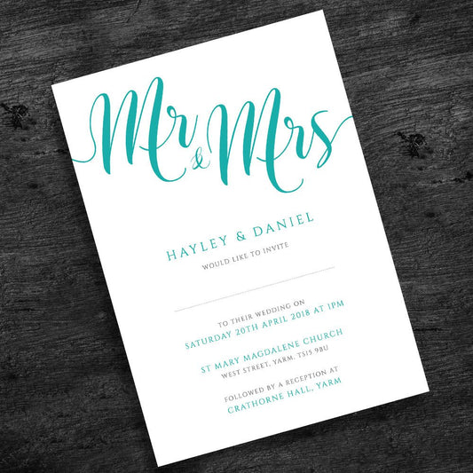 turquoise wedding invitation on wooden table