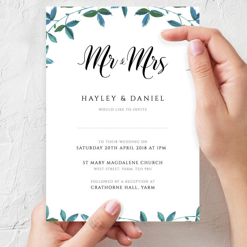 wife holding greenery border wedding invitation