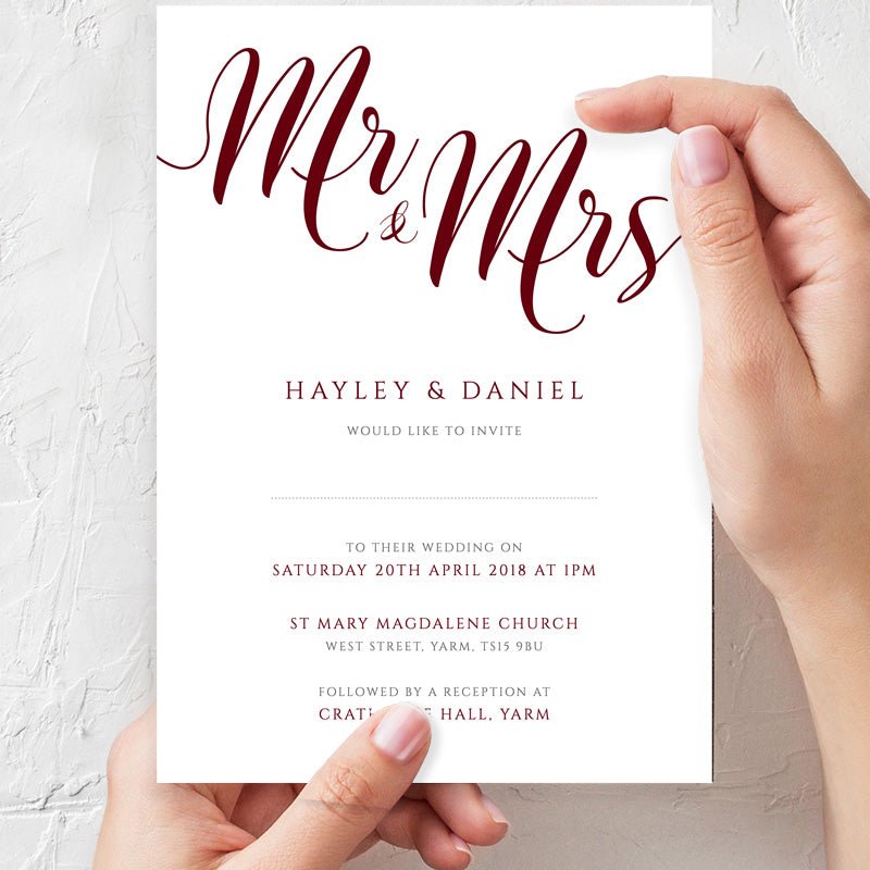 woman holding auburn wedding invitation in hands