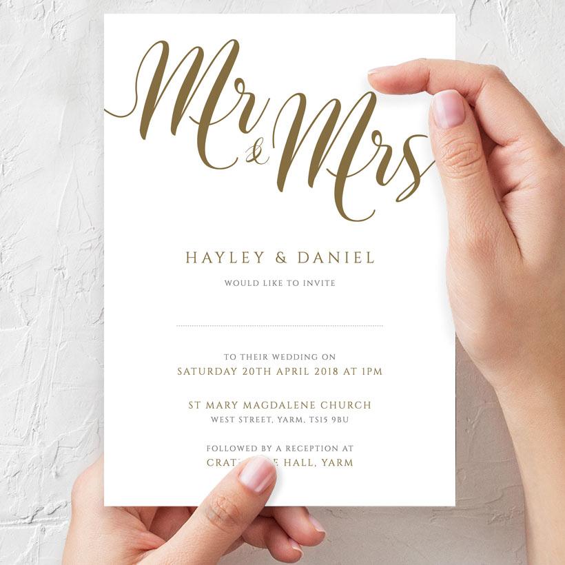 bride to be holding mr & mrs gold wedding invitation