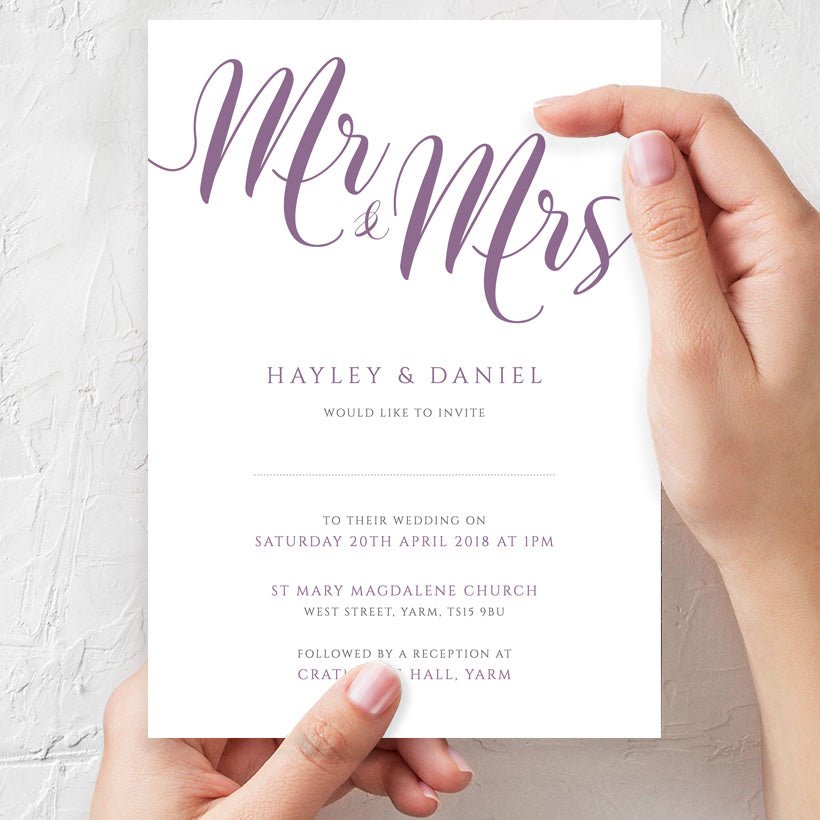 woman holding lavender purple wedding invitation in hands