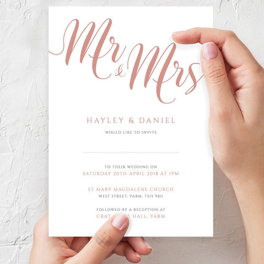woman holding peach wedding invitation in hands