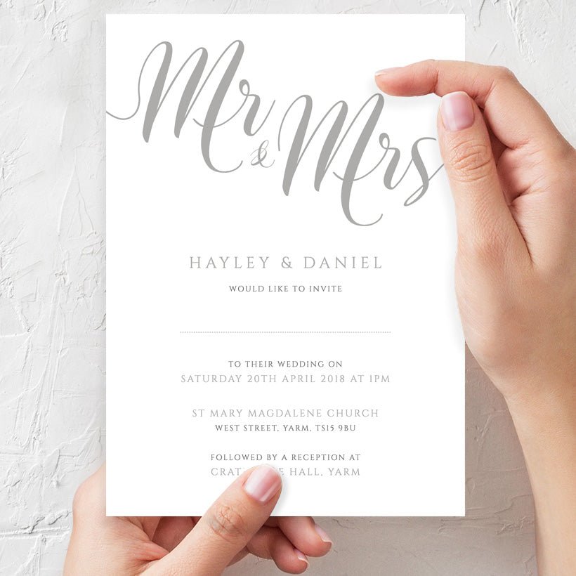 woman holding silver wedding invitation in hands