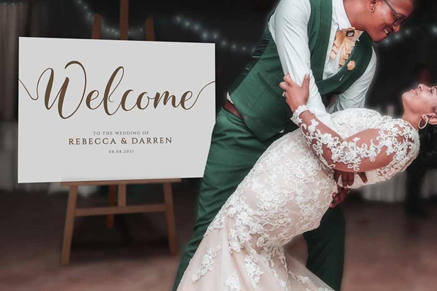 Wedding couple dancing on the dancefloor with a printed welcome sign in the background