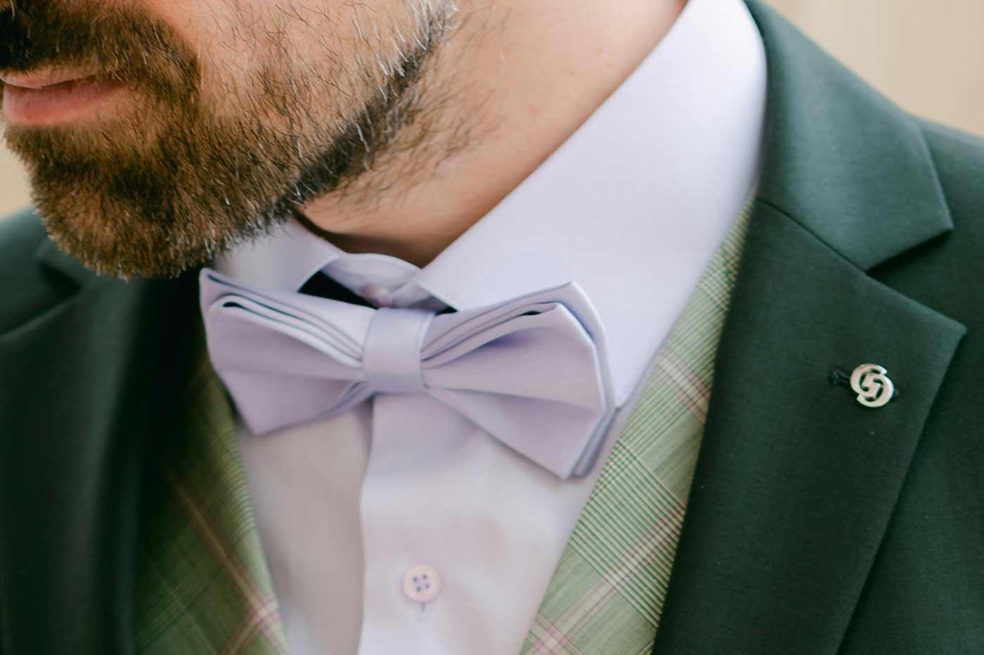Close up a groom wearing a bow tie at a wedding