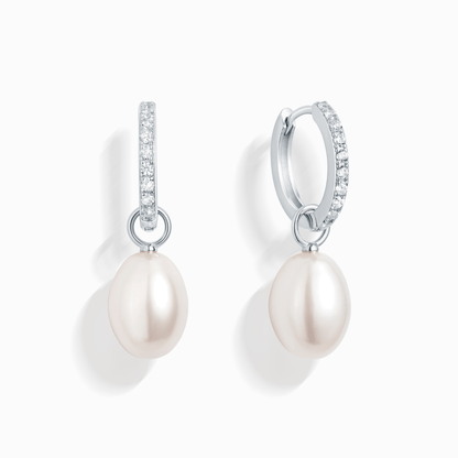 Two pearl drop earrings, each with a small pearl suspended from a silver hoop with small gems.