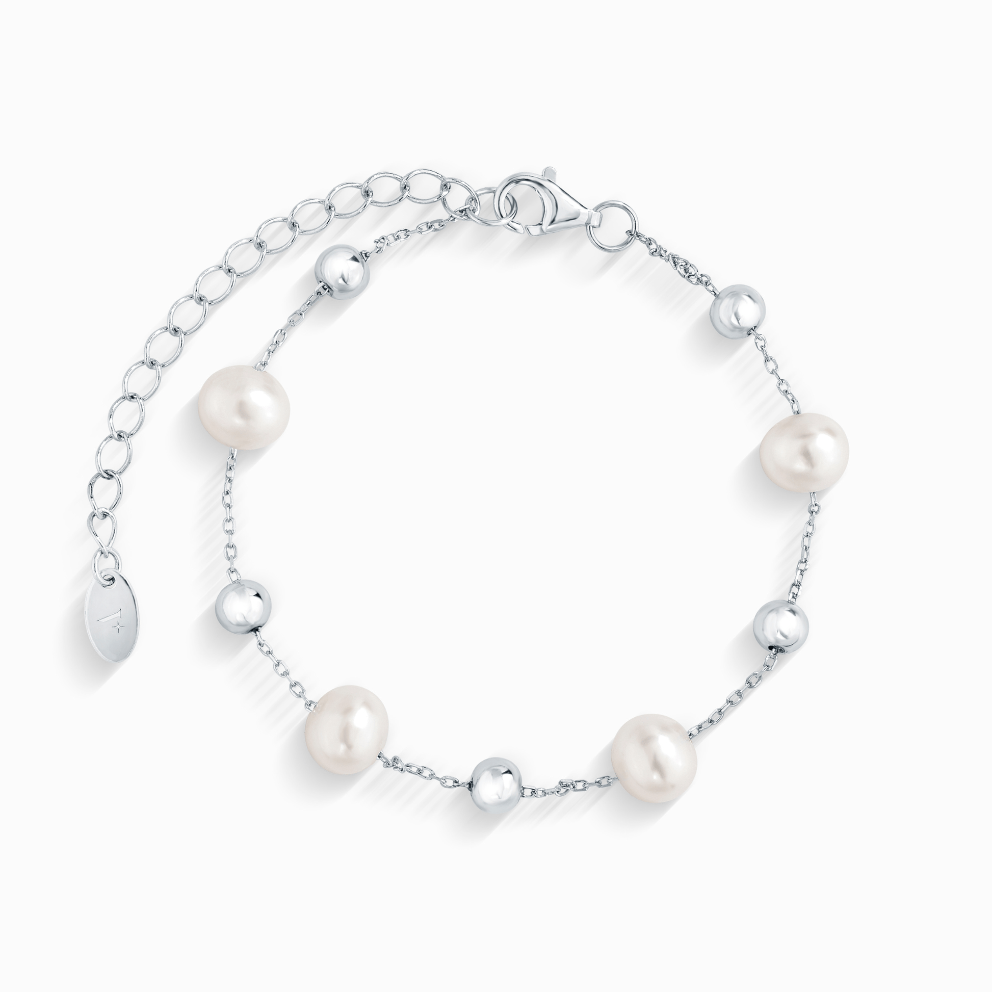 A close-up of a silver chain bracelet with five evenly spaced white pearls and silver beads.