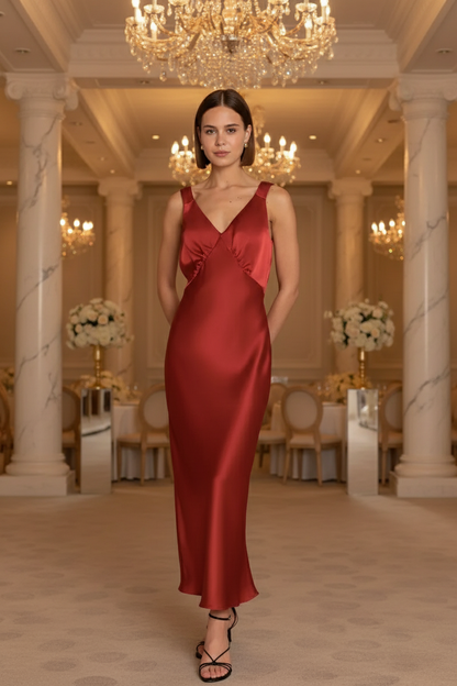 Bridesmaid in a chilli tomato red Bridesmaid dress standing in an elegant wedding venue with chandeliers and marble columns.