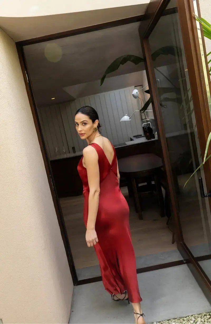 Bridesmaid in a red dress standing in a modern indoor setting.