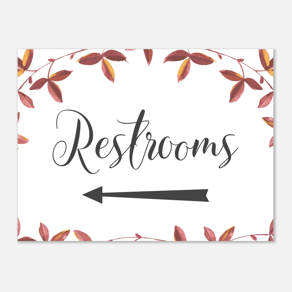 A rectangular restroom directional sign with a white background, a watercolor wreath of autumn leaves around the border, and a large black script word 'Restrooms' above a left-pointing arrow.