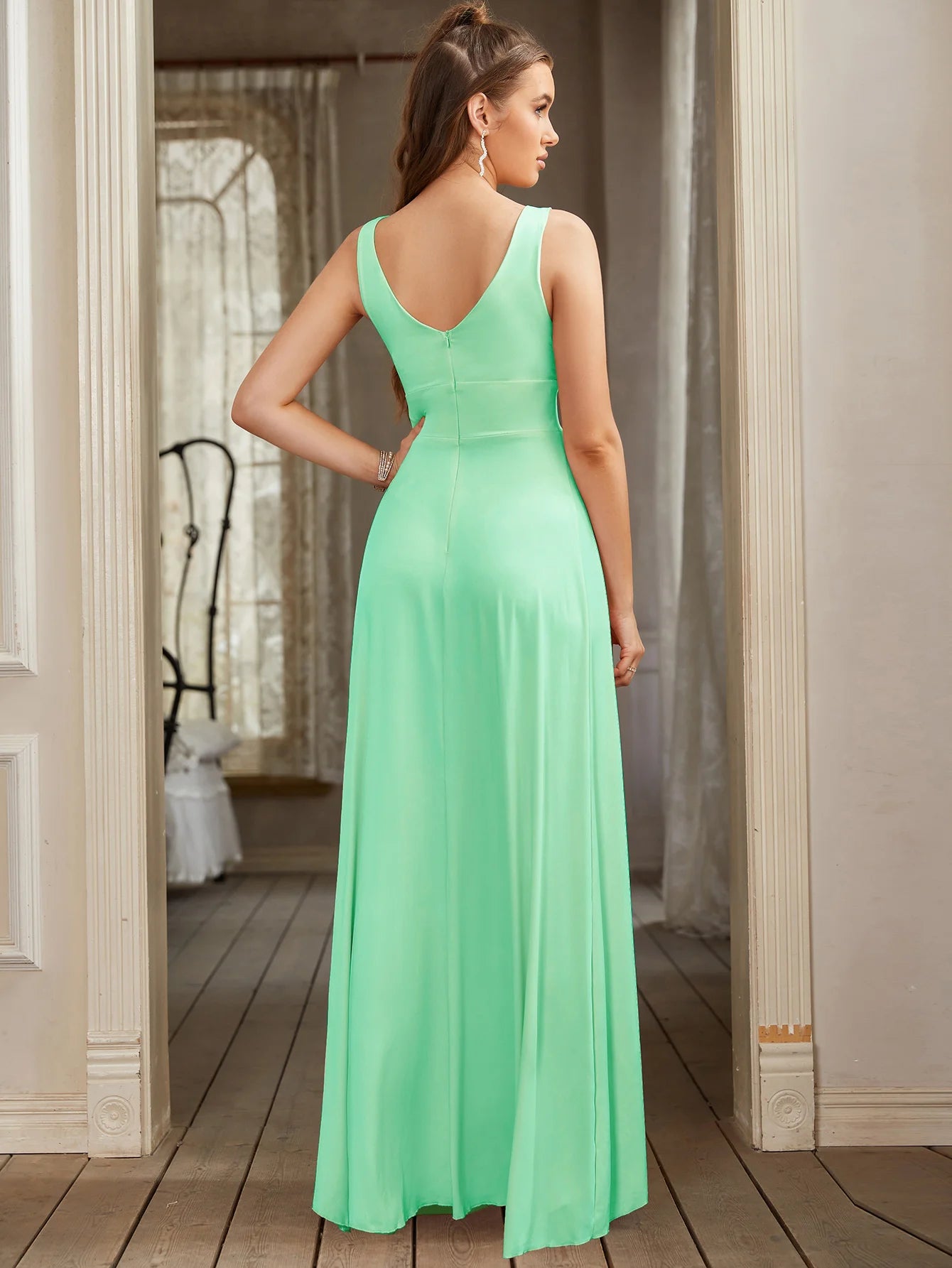 back view of woman wearing mint green split leg v-neck backless maxi bridesmaid dress