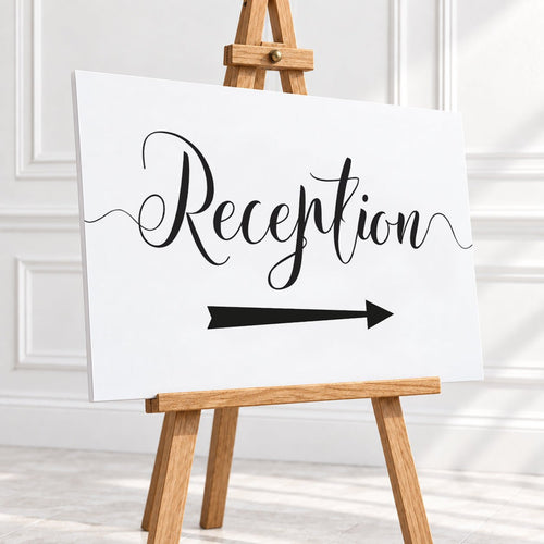 A white reception sign with black script lettering and a black arrow pointing right, displayed on a wooden easel in a bright indoor setting.