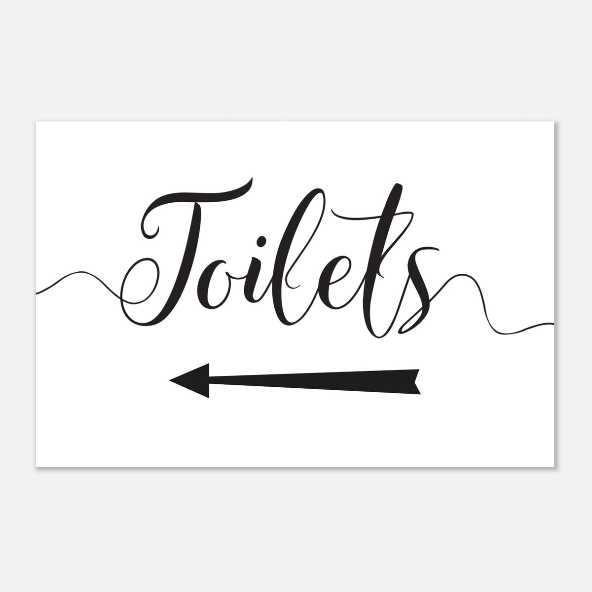 A rectangular white sign with black script reading 'Toilets' and a black left-pointing arrow below, shown on a light gray background.