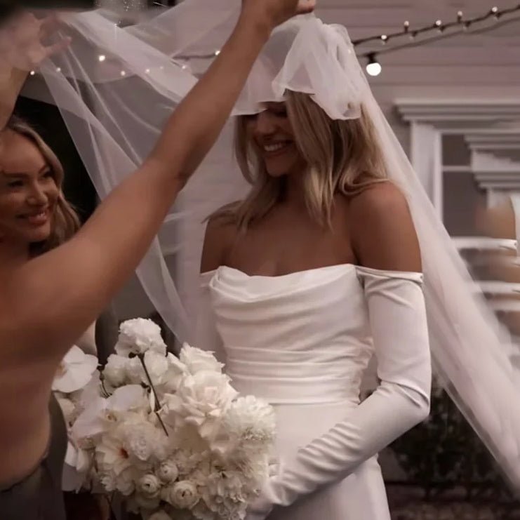 bride and bridesmaids smiling wearing a white Off-the-Shoulder Modern Satin Mermaid Wedding Dress with Long Sleeves