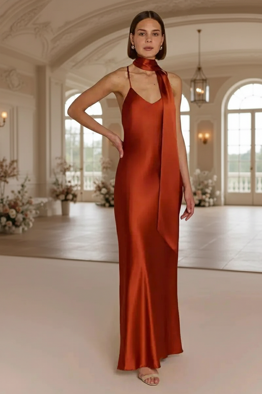 Bridesmaid wearing a burnt orange rust-colored Bridesmaid dress with a long scarf in an elegant wedding reception hall 