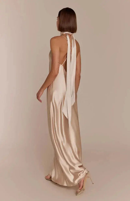 Woman wearing a satin champagne Bridesmaid dress with scarf on a plain background