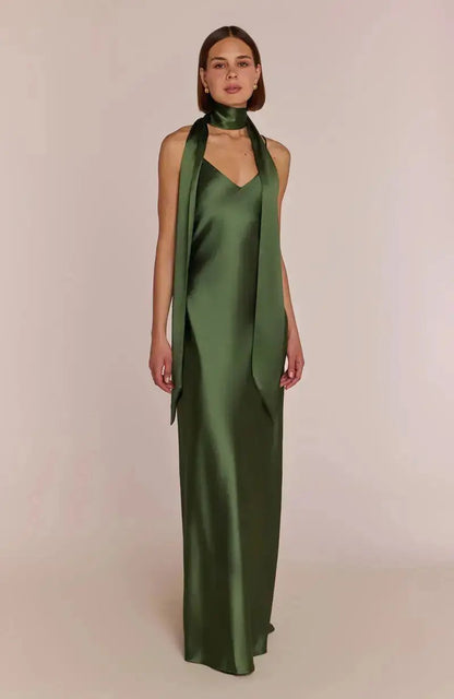 bridesmaid wearing a olive green satin dress with a matching scarf on a beige background