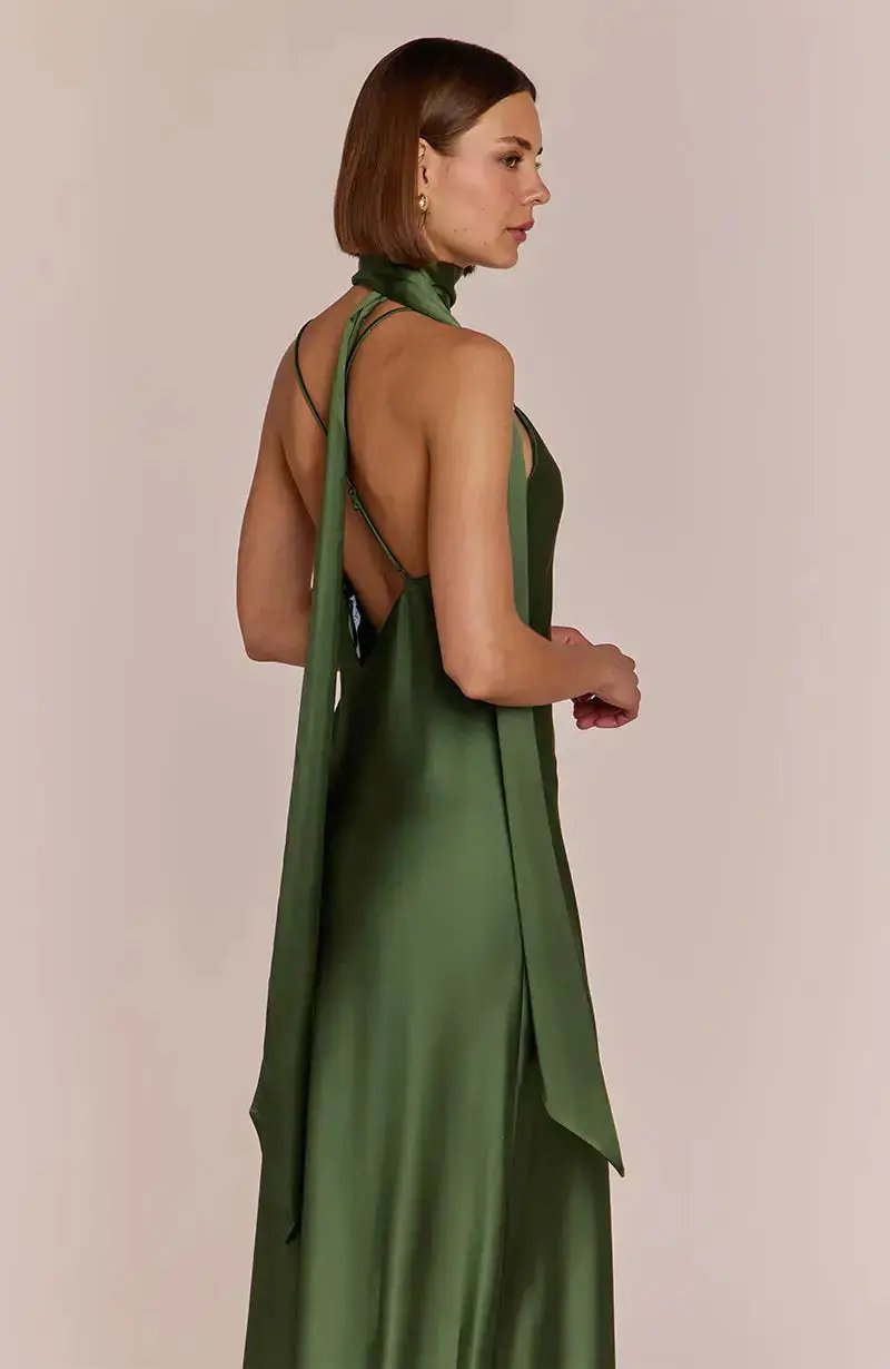 bridesmaid wearing a olive green dress with a plain background
