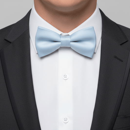 Light blue bow tie worn with a black suit and white shirt on a gray background