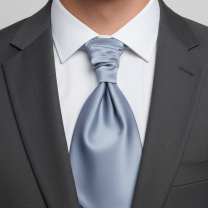 Man wearing a gray suit with a light blue tie against a neutral background