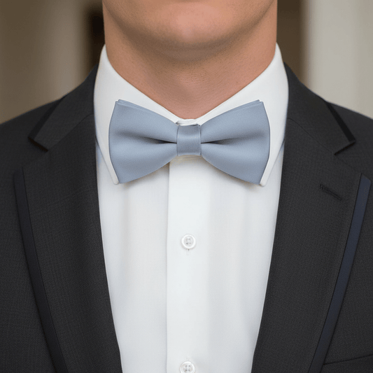 Man wearing a black suit with a white shirt and light blue bow tie.