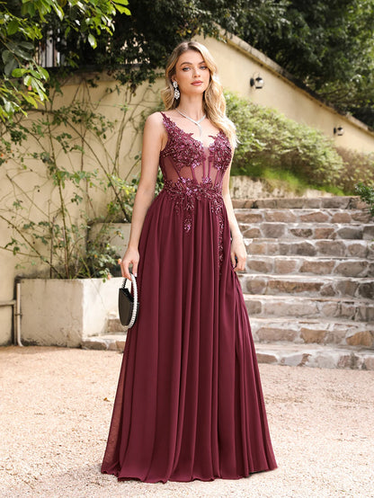 front side view of girl outside wearing a burgundy luxury backless beaded a-line prom dress