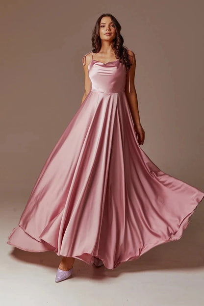 front view of girl wearing dusty pink satin side slit backless prom dress with spaghetti straps