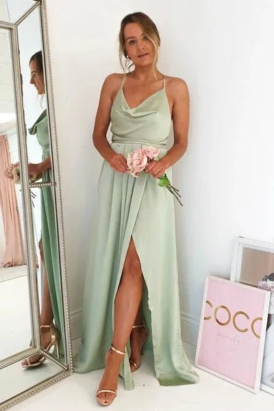 girl in mirror wearing mint green satin side slit backless prom dress with spaghetti straps