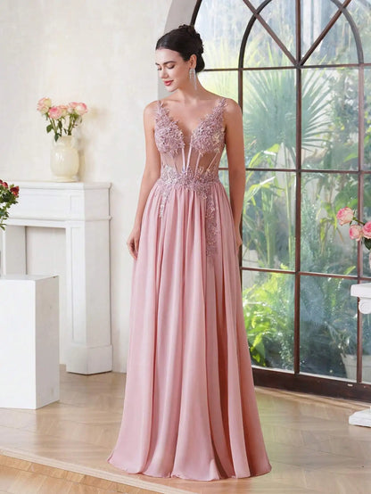 girl looking down wearing a pink luxury backless beaded a-line prom dress