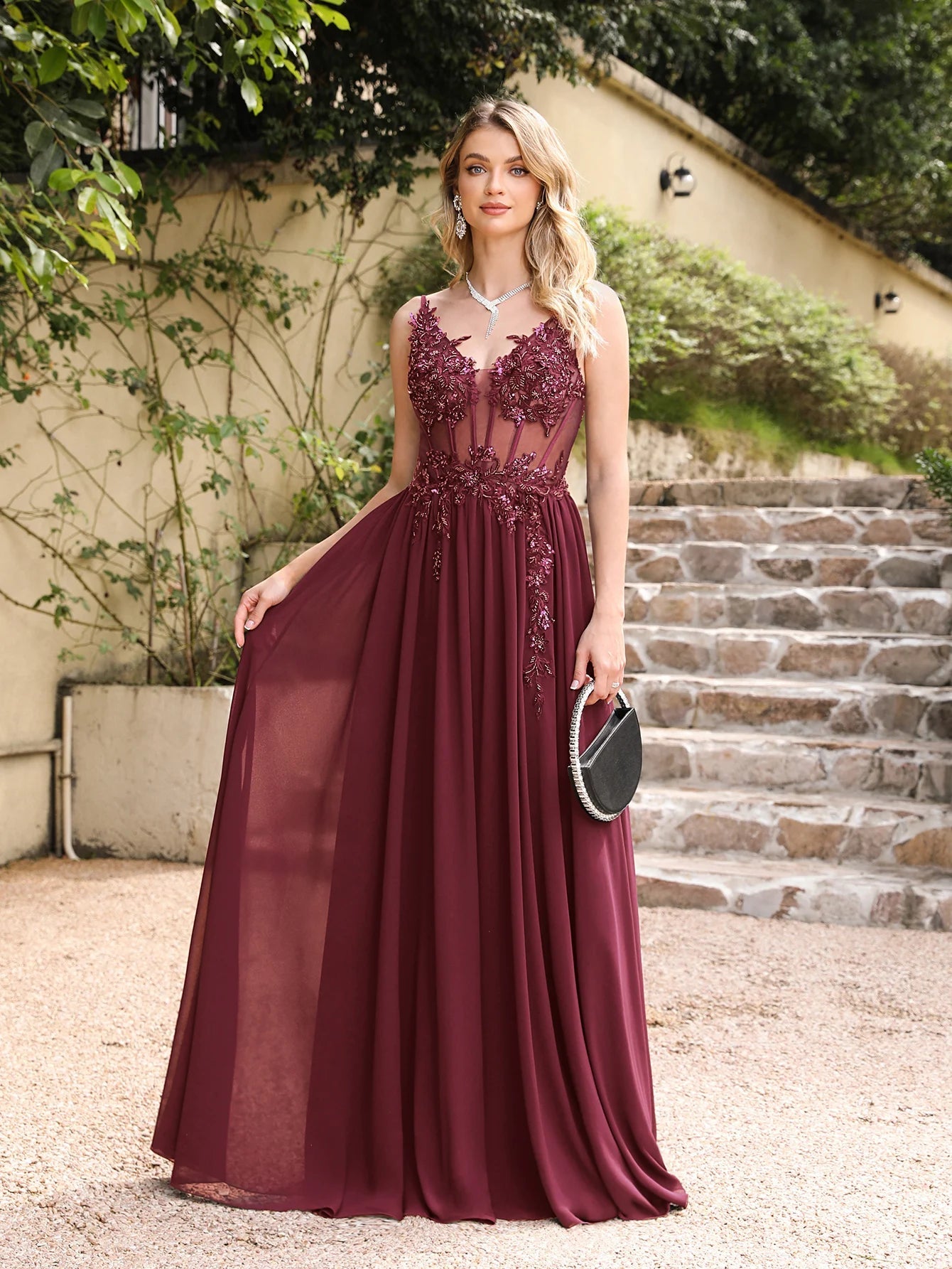 girl outside holding a burgundy luxury backless beaded a-line prom dress