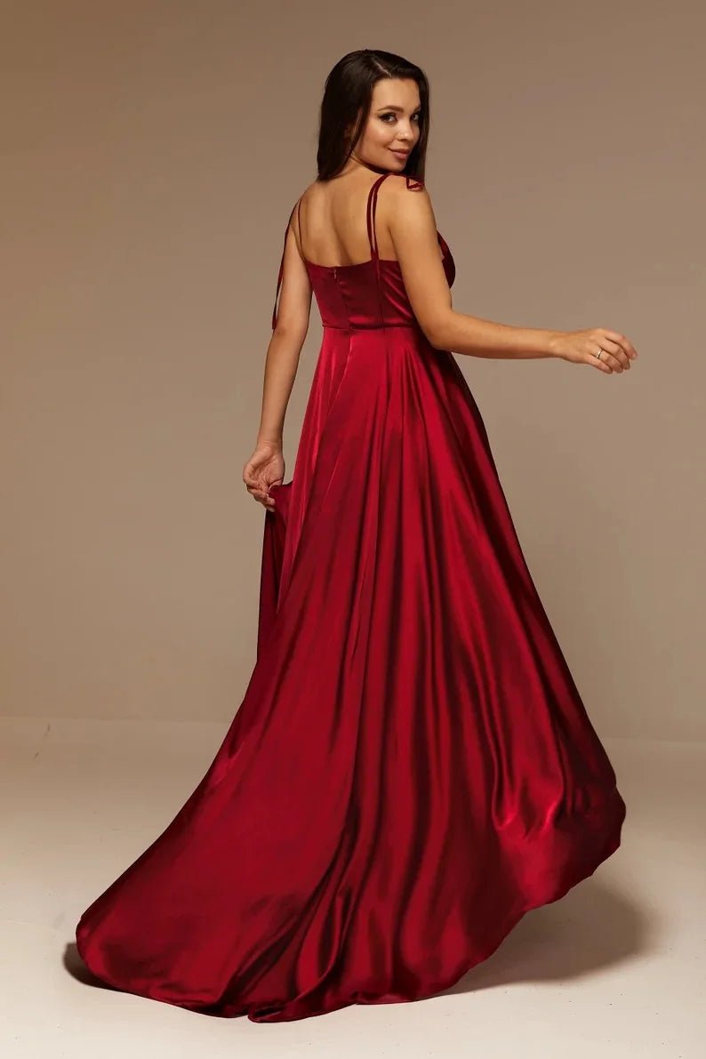 rear view of girl wearing burgundy satin side slit backless prom dress with spaghetti straps